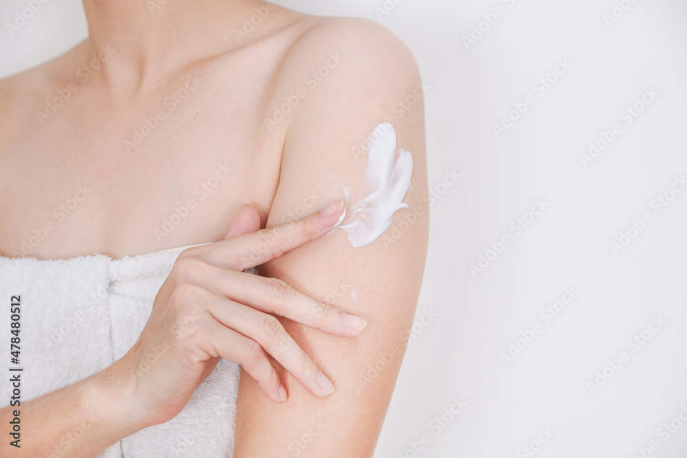 Fototapeta premium Woman applying cream,lotion on arm with white background, Beauty concept.