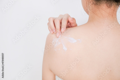 Woman applying cream,lotion on back with white background, Beauty concept.