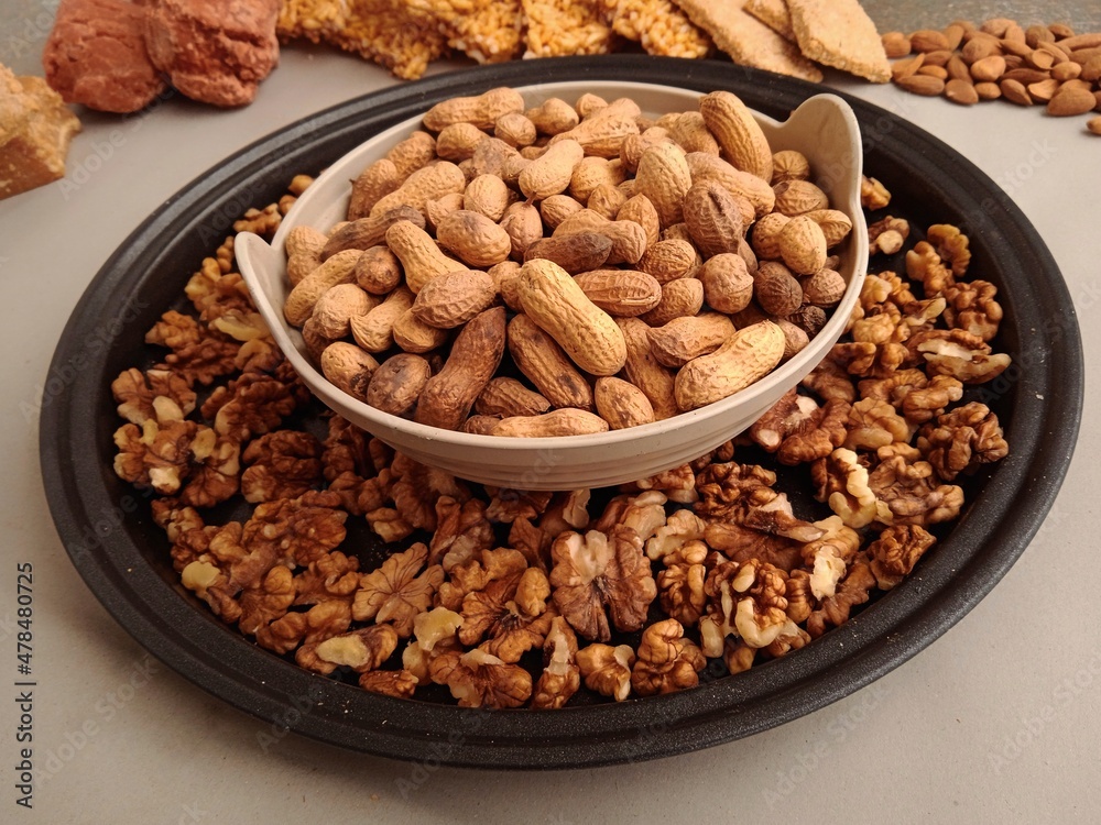Dry fruits for winter. Groundnuts or peanuts in a bowl with some walnuts and other sweets in background. Dry fruits for winter. Groundnuts or peanuts in a bowl with some walnuts and other sweets in background.