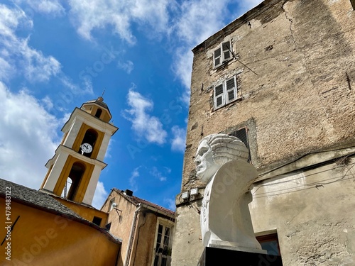 Pascal Paoli bust and church tower of Saint Erasme in Cervione, a dreamy village nestled in the mountains of Castagniccia. Corsica, France.  photo