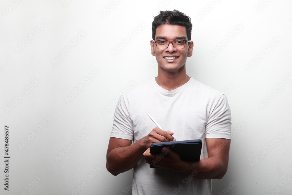 Smiling young man of Indian origin holding a tablet computer Smiling young man of Indian origin holding a tablet computer