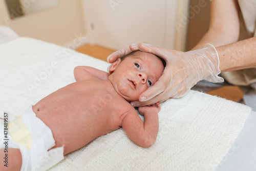 Physiotherapist performing coronal suture work on a newborn baby in a therapy center. photo