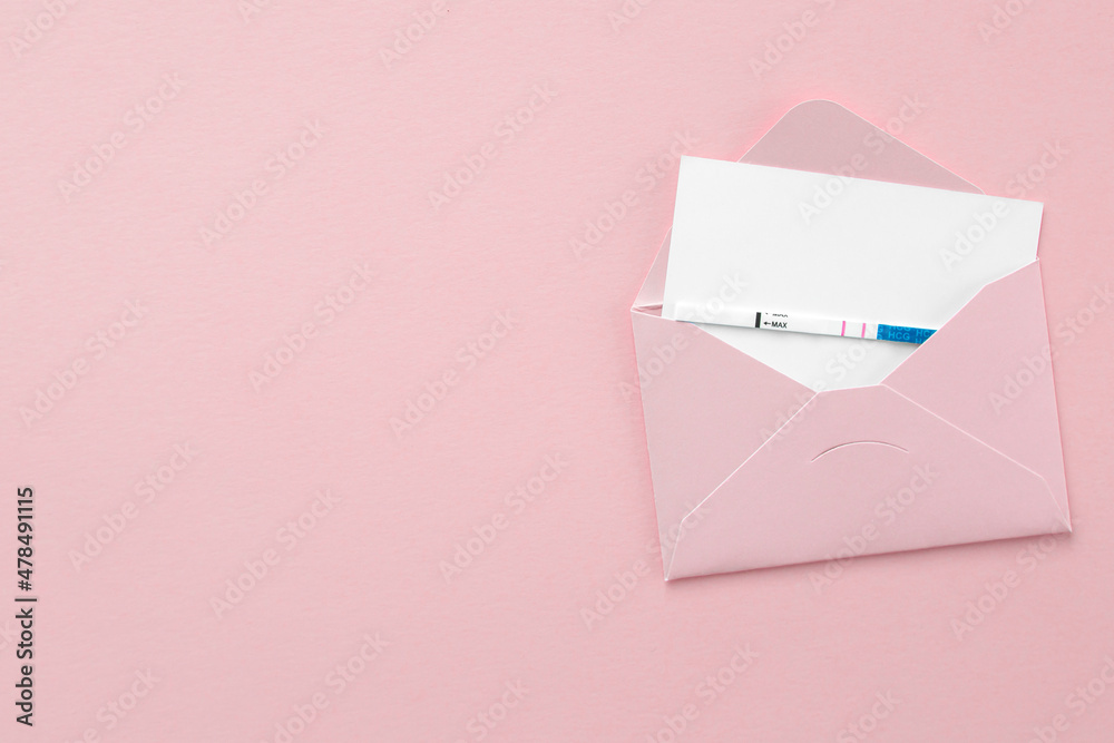 positive pregnancy test in pink envelope on pink background, postcard with place for text, pregnancy concept. positive pregnancy test in pink envelope on pink background, postcard with place for text, pregnancy concept.