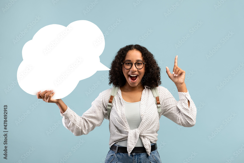 Happy black woman holding blank speech bubble, having creative idea on blue studio background, mockup for design