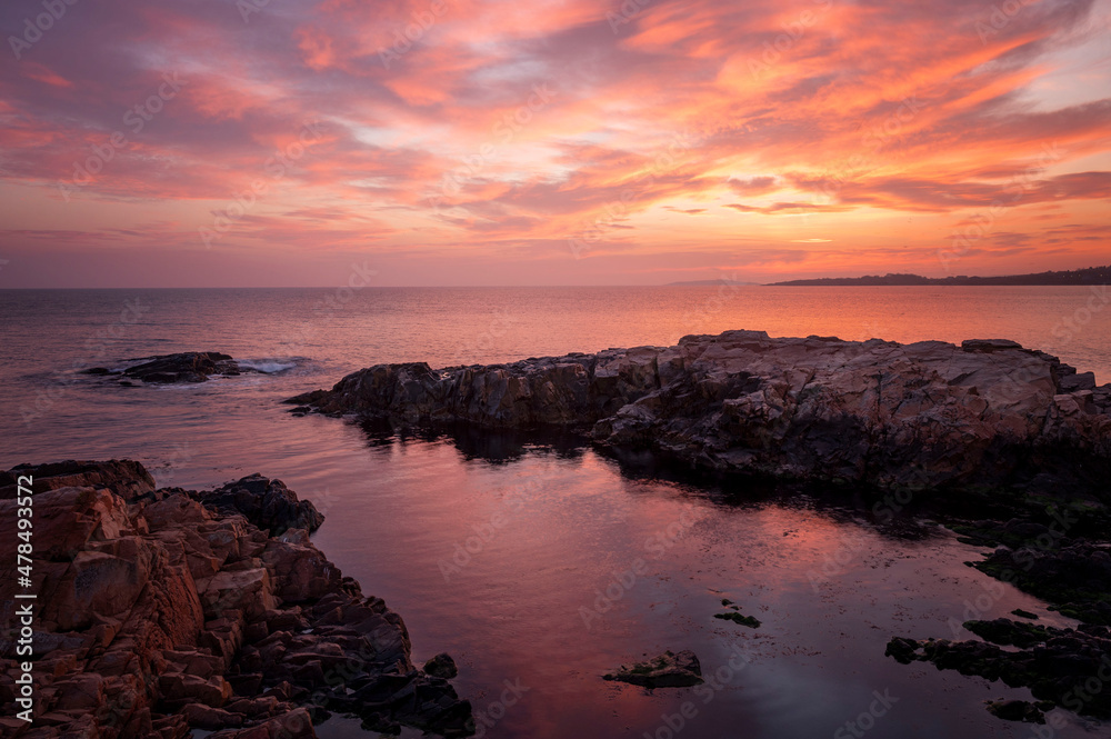 Coast sea. Sunset. Sunrise. Wild rock beach. The natural rock formation. Red sun over summer sea. Cloud on a blue sky over summer sea. Black sea, Bulgaria