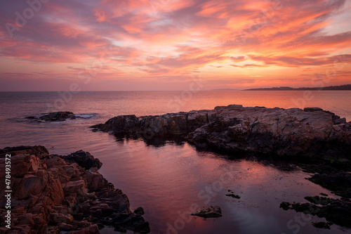 Coast sea. Sunset. Sunrise. Wild rock beach. The natural rock formation. Red sun over summer sea. Cloud on a blue sky over summer sea. Black sea, Bulgaria
