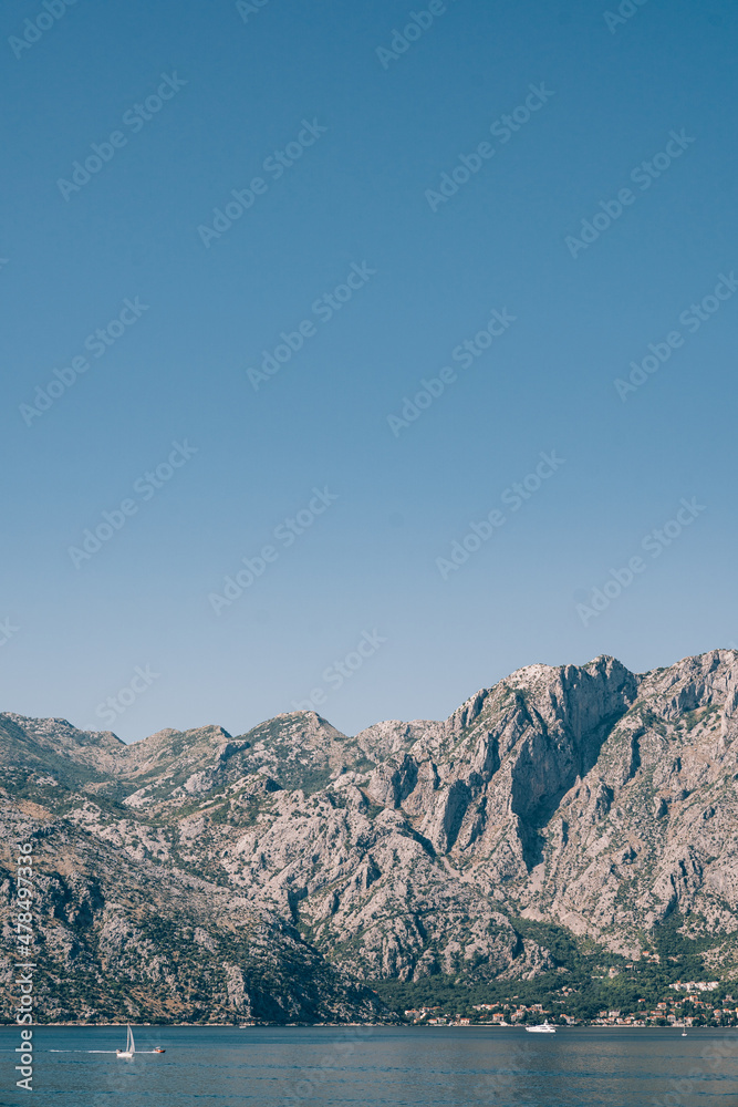 Huge mountain range on the shore of the Kotor Bay against the background of blue sky