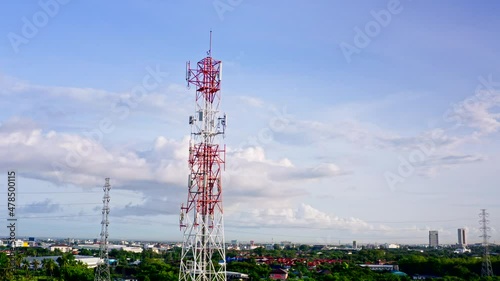 Telecommunication tower in suburban area with mountain and city in background. Aerial View. Day time