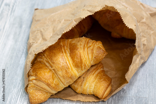 Freshly baked croissants in a brown paper bag.  Recycle plastic free packaging concept