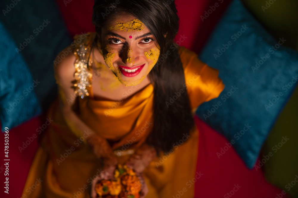 Overhead view of an Indian bride with turmeric paste on face Overhead view of an Indian bride with turmeric paste on face