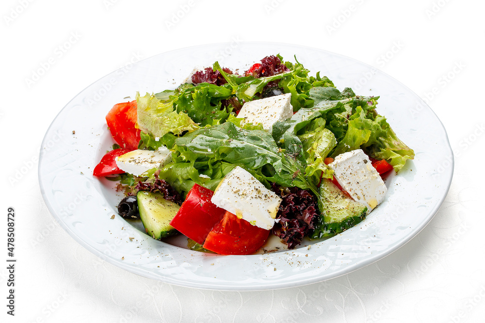 Greek salad with fresh vegetables and feta cheese. Isolated on a white background Greek salad with fresh vegetables and feta cheese. Isolated on a white background