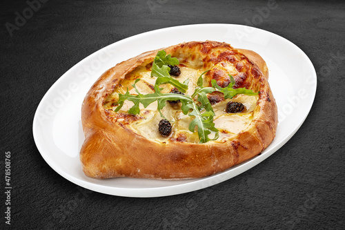 Traditional Georgian cuisine. Adjarian khachapuri. Isolated on a black background.