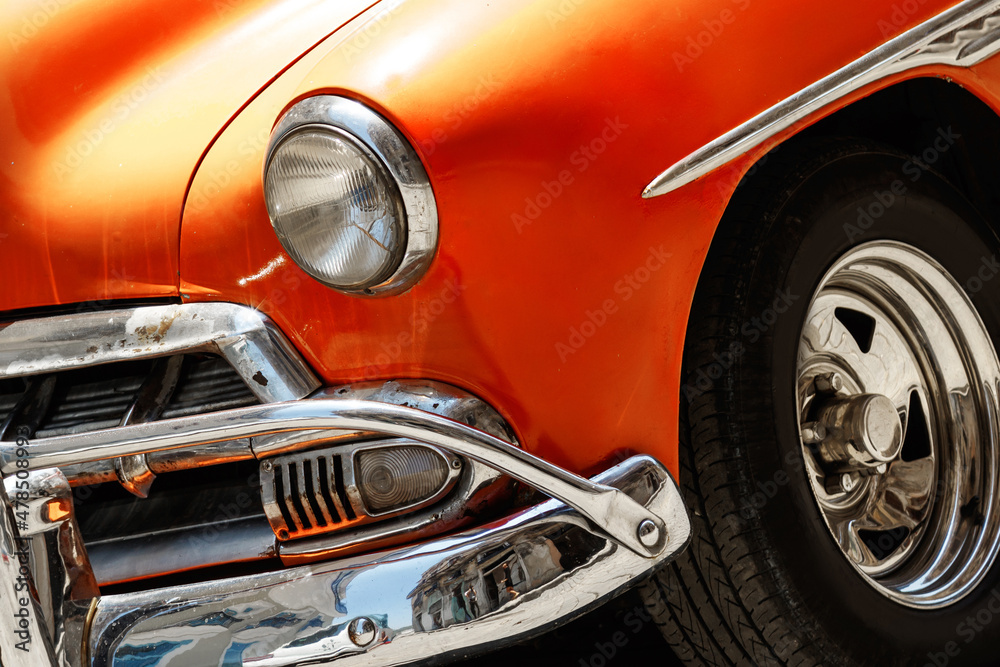 Shiny vintage orange car parked on street