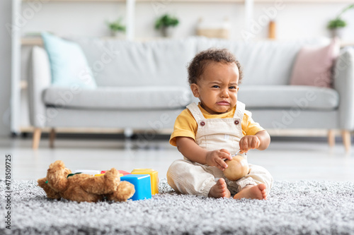 Wall Mural Crying Cute African American Infant Boy Sitting On Floor In Living Room