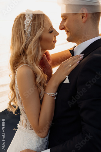 Portrait of gorgeous bride and handsome groom in moving for kiss, happy young couple