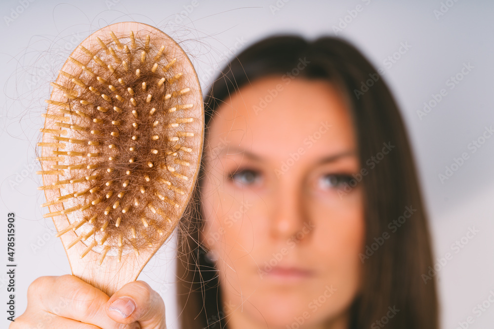 Woman showing hair brush with damaged hair. Hair loss problem. Bad hair falling out - obrazy, fototapety, plakaty 