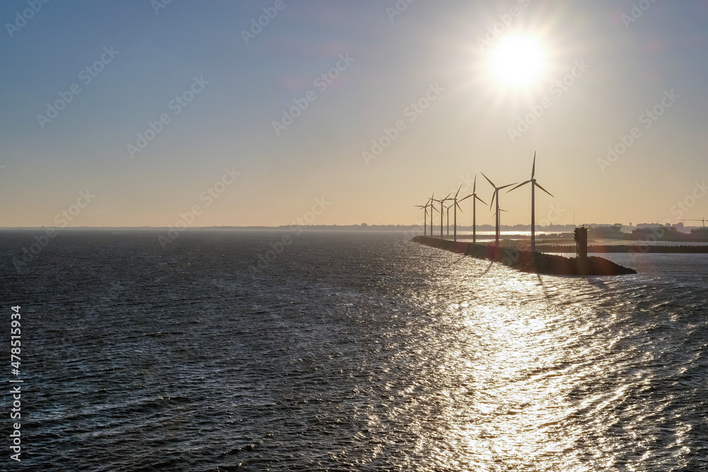Konzept Energiewende, alternative Energien oder Umweltschutz: Windräder an der Küste in der Abendsonne, sehr viel Copyspace