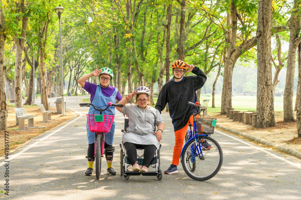 group of Asian friends with down syndrome riding bicycle and wheelchair group of Asian friends with down syndrome riding bicycle and wheelchair