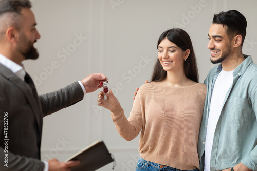 Real Estate Agent Giving Keys To Happy Arab Buyers photo