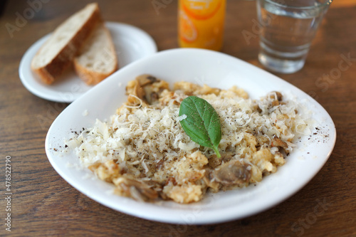 Risotto with mushrooms, fresh herbs and parmesan cheese. Traditional Italian food. Soft focus image.