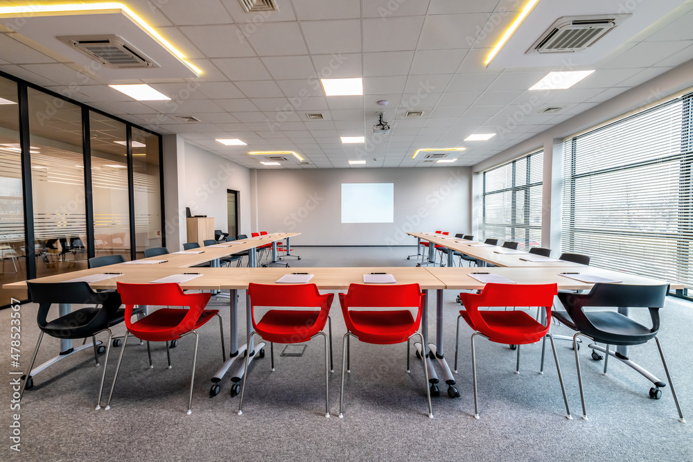 sala konferencyjna przygotowana do spotkania biznesowego. Czerwone krzesła  podkreślają ciekawą architekturę wnętrza - obrazy, fototapety, plakaty 