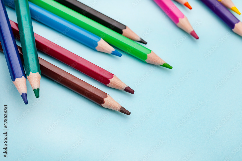 Naklejka premium Colored pencils on bright colored background