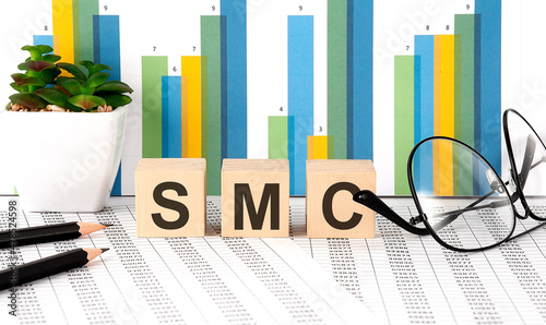 Foto SMC word written on the wood block with chart, glasses and pencils