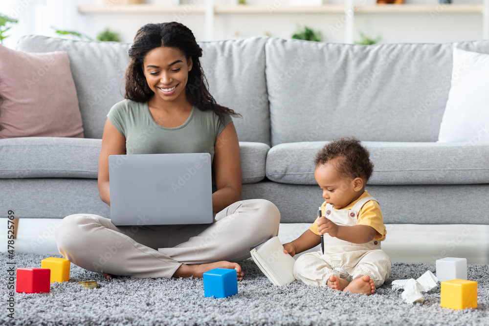 Remote Job. Young Black Mother Using Laptop And Taking Care About Baby Remote Job. Young Black Mother Using Laptop And Taking Care About Baby