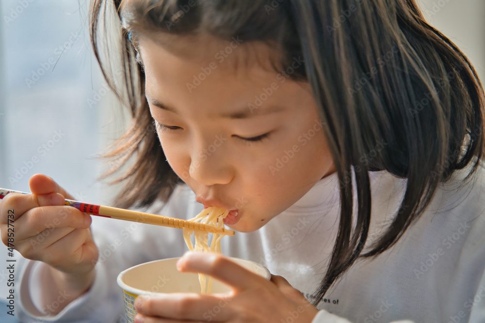 カップラーメンを食べる子供
