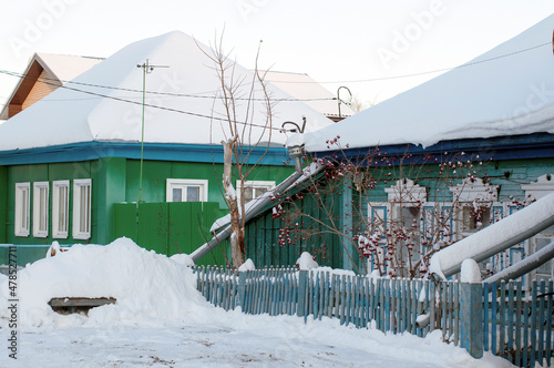 Several residential buildings on the snowy street of the village in Russia
