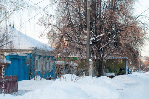 Several residential buildings on the snowy street of the village in Russia