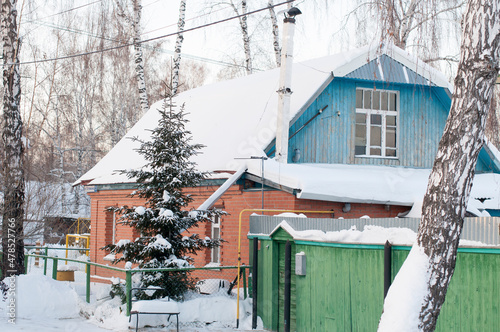 Several residential buildings on the snowy street of the village in Russia