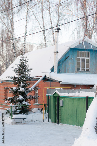 Several residential buildings on the snowy street of the village in Russia