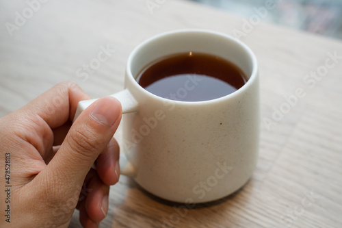 カフェでホットコーヒーを飲む女性