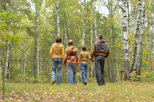 Portrait of family of four having fun in autumn forest