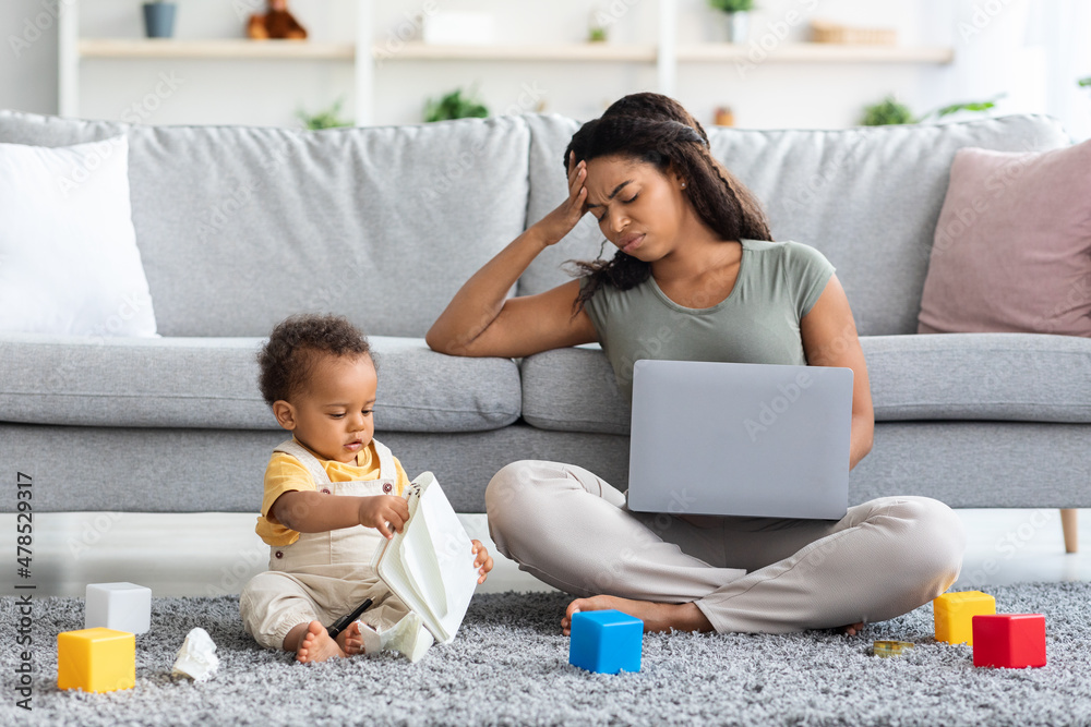 Stressed Black Woman Trying To Work On Laptop With Little Baby Around Stressed Black Woman Trying To Work On Laptop With Little Baby Around