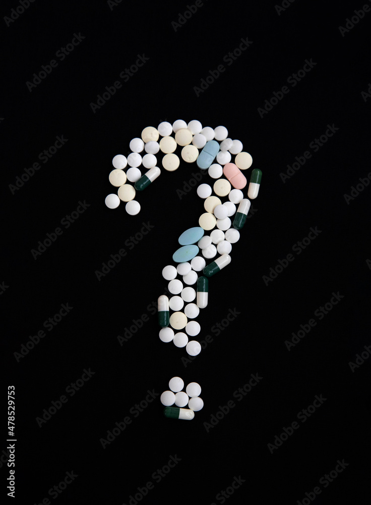 A question mark made of pills on a black background. The concept of vaccination and health protection A question mark made of pills on a black background. The concept of vaccination and health protection