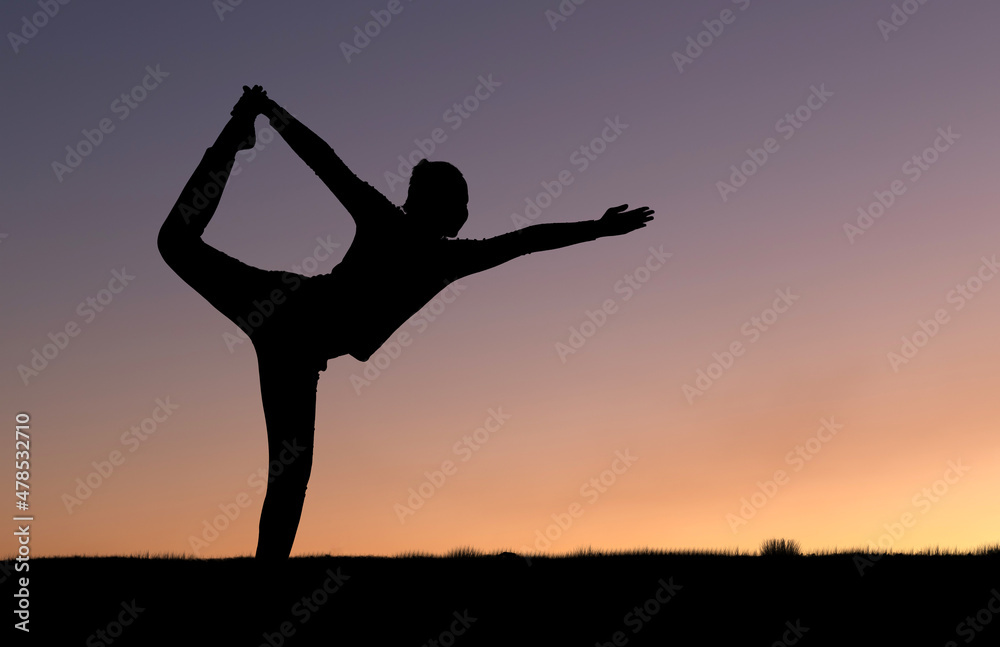 Silhouette of female doing yoga in the mountains at sunrise sky background Silhouette of female doing yoga in the mountains at sunrise sky background