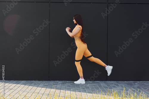 Fitness everyday routine. Young woman in sportswear doing exercises outdoors