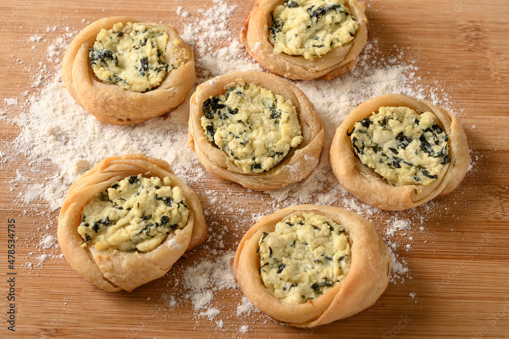 open sfiha filled with ricotta cheese and spinach on a wood