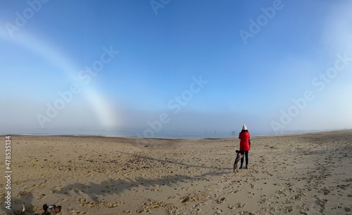 Fotografia Beautiful landscape with female couple walking with dog on misty environment on