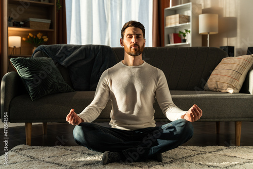 Caucasian man meditating in lotus pose and with closed eyes. Sport and healthy lifestyle concept photo