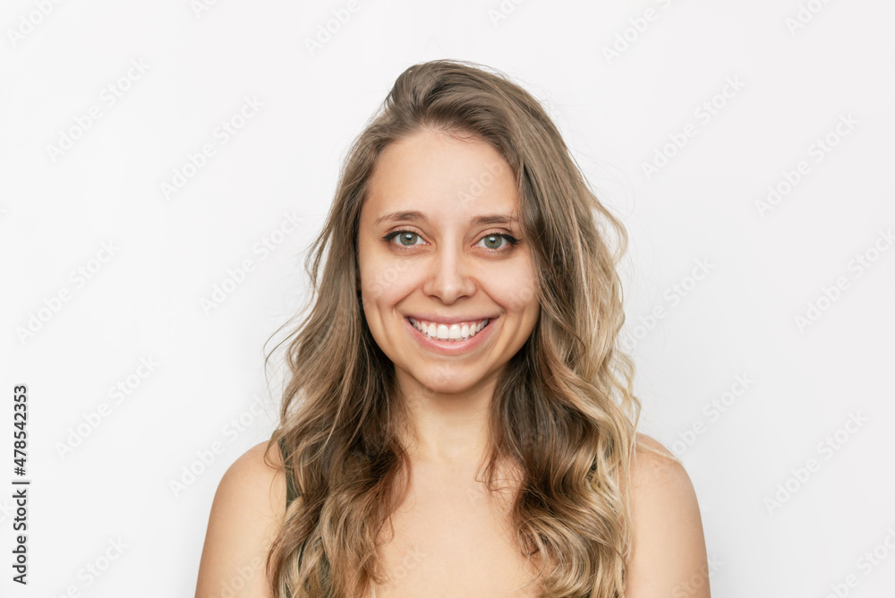 Portrait of a young attractive happy caucasian smiling blonde woman with wavy hair isolated on a white background. Charming cheerful girl with green eyes Portrait of a young attractive happy caucasian smiling blonde woman with wavy hair isolated on a white background. Charming cheerful girl with green eyes