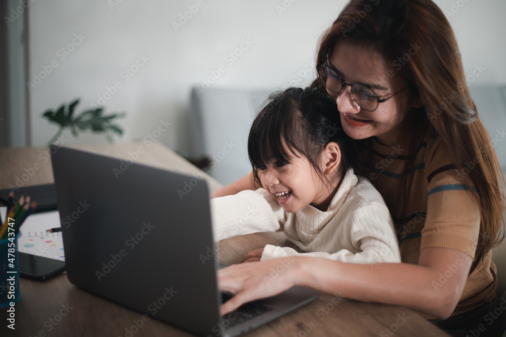 Mother working at home-office with daughter on her lap Mother working at home-office with daughter on her lap