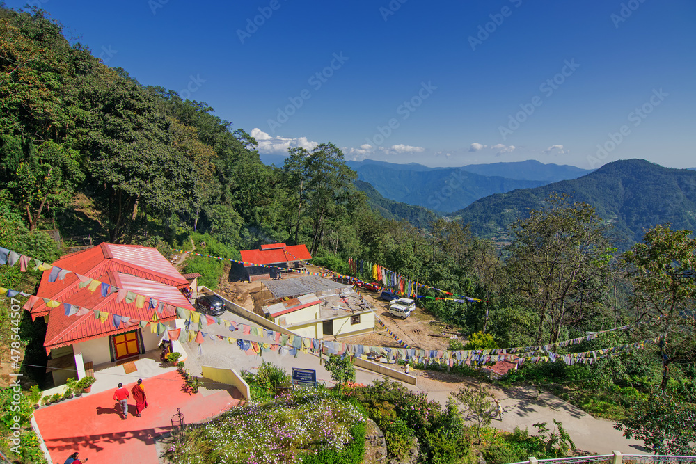A beautiful sunlit Buddhist Monastery - Samdruptse at Ravangla city, Sikkim , India. Blue cloudy sky above and Himalayan Mountains in the background.