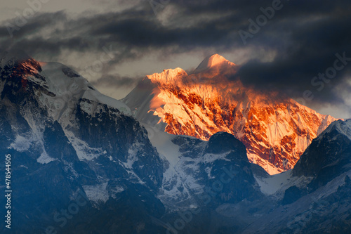 Beautiful first light from sunrise on Mount Kanchenjugha, Himalayan mountain range, Sikkim, India. Orange tint on the mountains at dawn