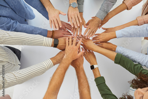 Team of people joining hands in corporate meeting. Group of coworkers, teammates and friends putting hands together. Business, union, teamwork, partnership concept. Close up, top view, shot from above