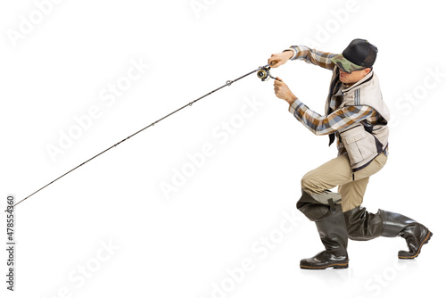 Portrait of young man, professional fisherman with fishing rod, spinning and equipment fishing isolated over white studio background
