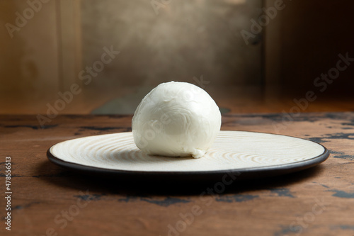 A ball of mozzarella cheese on a wooden table.