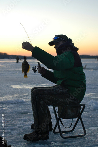 An angler with a bluegill caught at sunset  photo